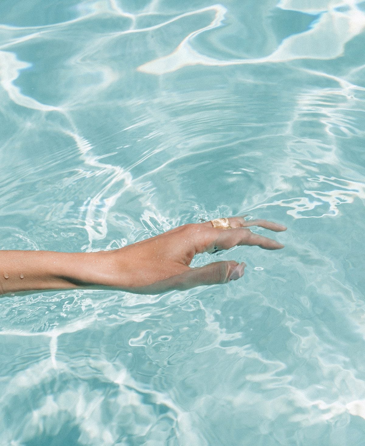Woman's hand in pool water
